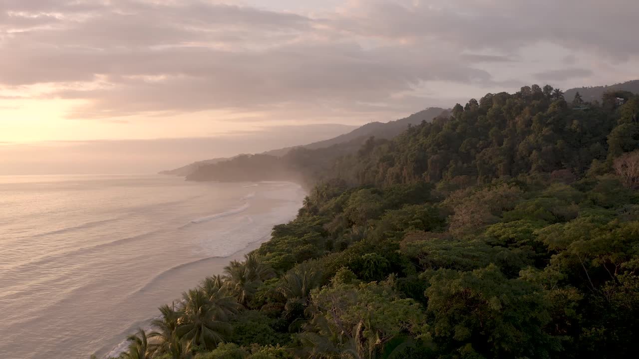 la jungla se encuentra con el océano en la playa de punta uvita en el oeste de costa rica centroamérica durante la puesta de sol, tiro aéreo