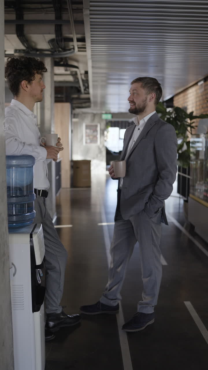 Businessmen talking in the office corridor during a coffee break