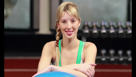 mujer en forma sonriendo a la cámara en el gimnasio