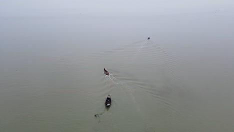 aerial view of an engine motor and fishing boat leaving shore of kuakata in bangladesh