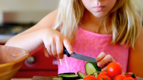 chica cortando verduras en la cocina 4k