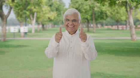 Indian-old-man-showing-thumbs-up-in-park