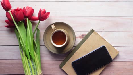 Flat-composition-coffee,-tulip-flower-and-eyeglass-on-wooden-background