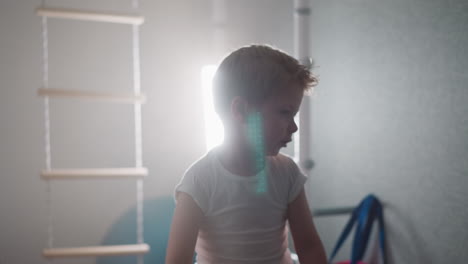 cute toddler warms up before intensive training in gym