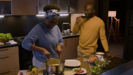 una pareja cocinando en la cocina.