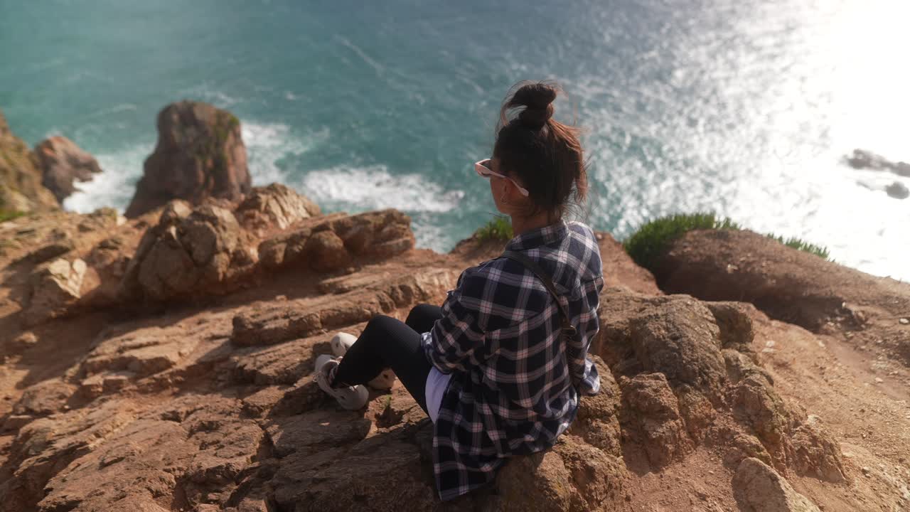 mujer disfrutando de la vista desde un acantilado costero