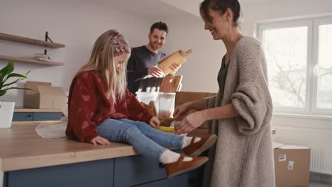 video de mano de una familia caucásica desempaquetando cosas de la cocina mientras se muda de casa.