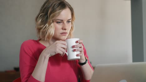 sad woman drinking a cup of tea after reading a mail