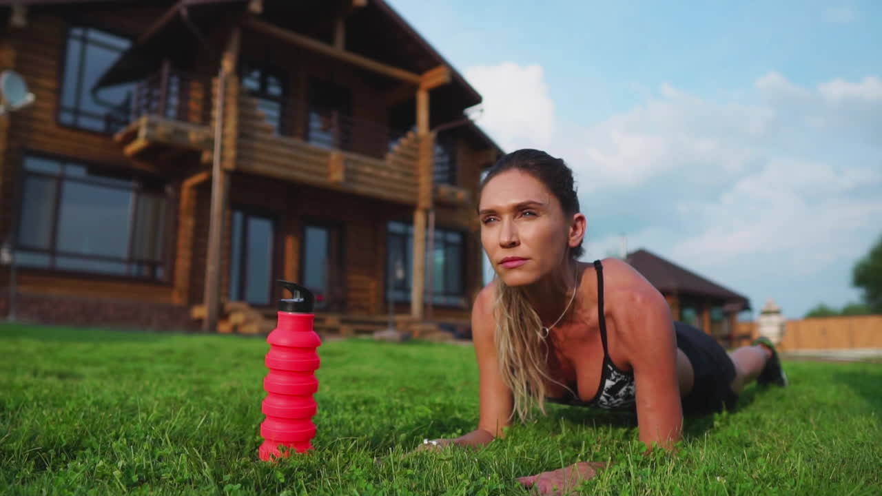 뜨거운 여름날 공원에서 바 ⁇ 에서 보드 운동을 하는 적합한 소녀