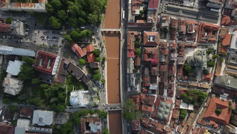 Drohnenaufnahme-Der-Reichen-Bosnischen-Stadt,-In-Der-Das-Kulturelle-Erbe-Zusammenlebt,-Luftaufnahme-Des-Flusses,-Der-Mitten-Durch-Die-Stadt-Fließt