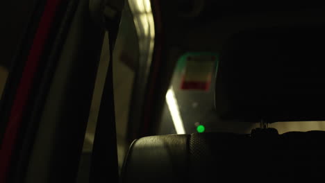 passenger seat with security belt in modern car driving in tunnel at night with illuminated road