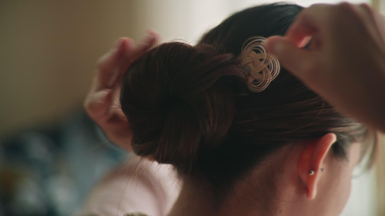 Woman styling her hair in a bun