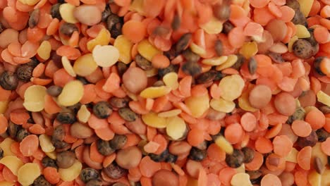 a vibrant mix of lentils and seeds cascades onto a surface, creating a colorful and textured display