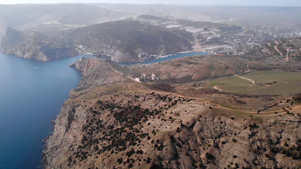 Aerial view of a scenic coastline with mountains and sea