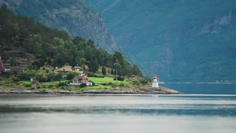 a miniature lighthouse, cabins, and cottages on the shore of the hardanger fjord