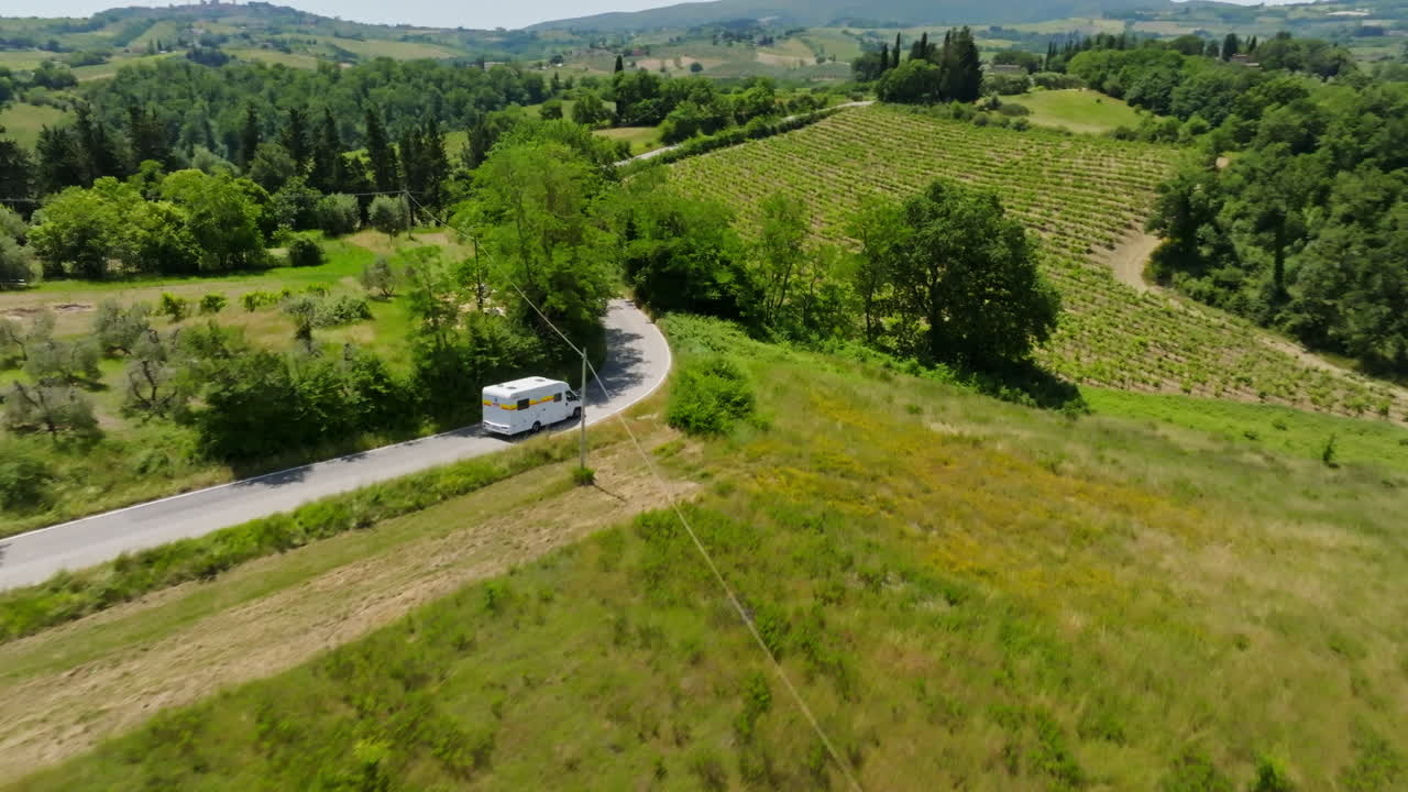 Aerial view of RV meeting a car on a narrow countryside road, in Tuscany, Italy