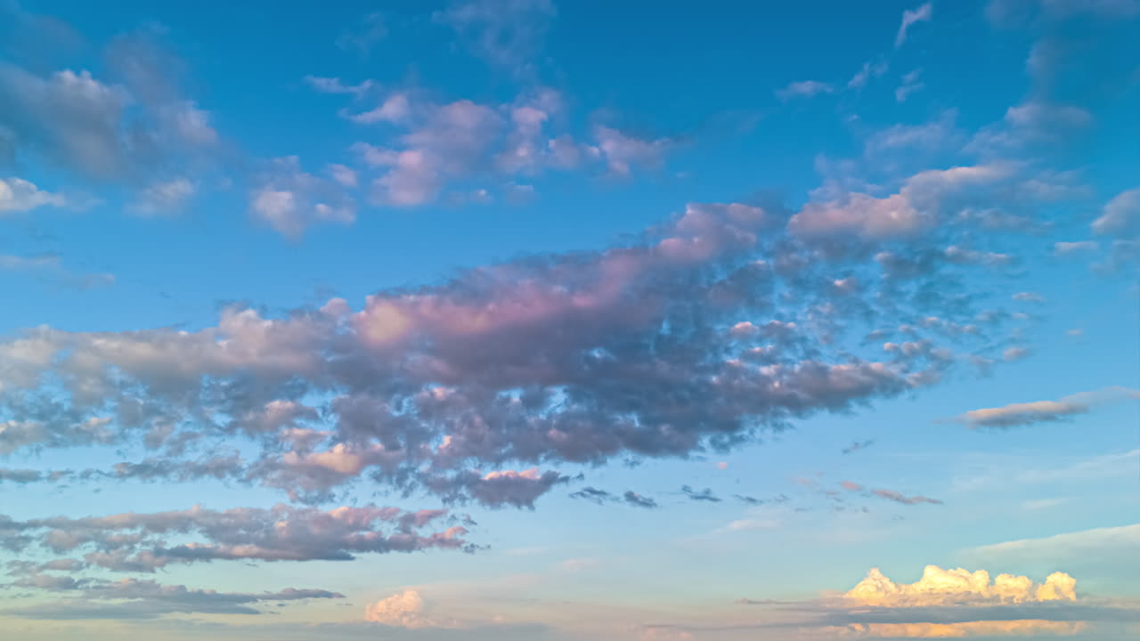 Drone hyperlapse of soft clouds drifting through blue sky during calm summer evening