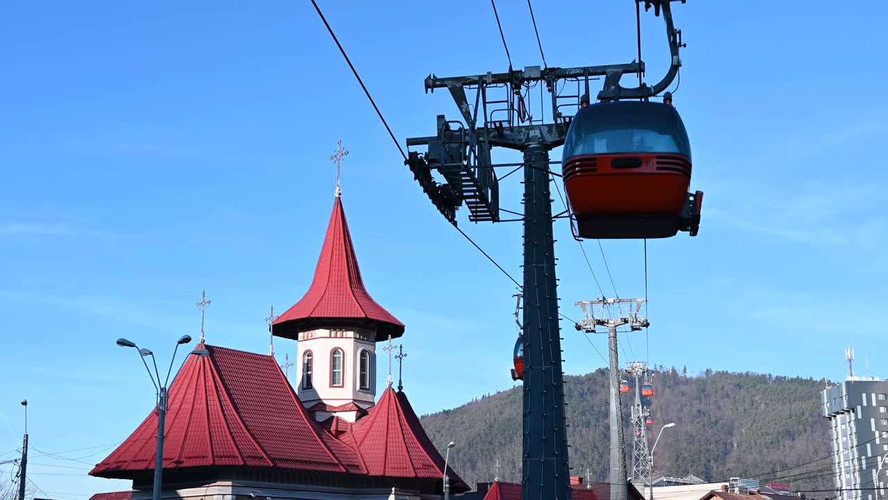 Gondola lift moving above Piatra Neamt, Romania, near the Pogorarea Sfantului Duh - Gara Church