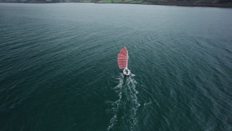 classic sailboat with old burgundy rigging, on a cold gloomy day