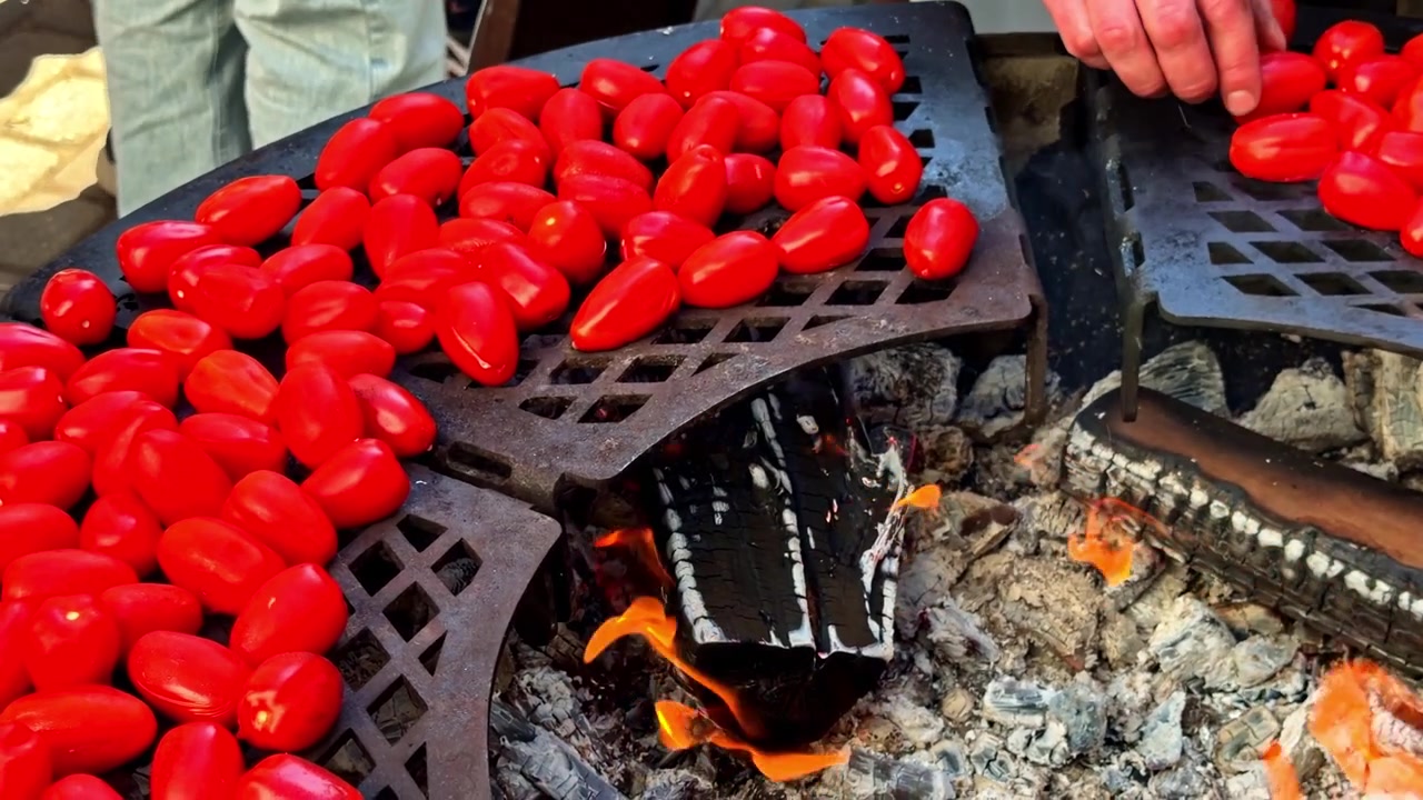 Açık havada yemek pişirme ortamında, açık kömür ateşinde közlenen taze kırmızı domatesler.