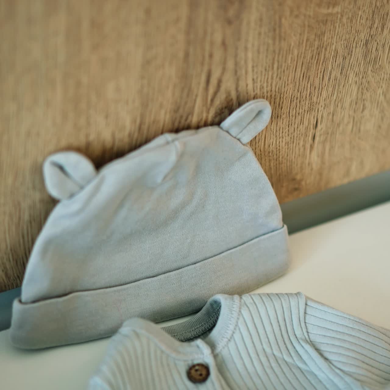 Cute tiny cap, shirt and socks for the newborn baby. Clothes prepared for the child by parents. Close up