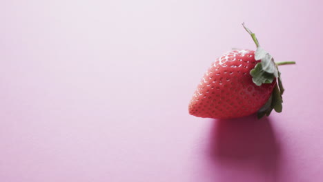 video of strawberry with copy space over pink background