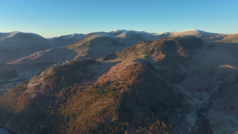 Frosted-mountains-bathed-in-early-morning-autumn-sunrise-with-slow-pan-revealing-range