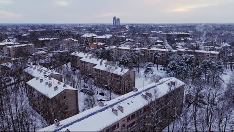 drone tilt reveals snowy rooftops of historic soviet-style flats in riga sunset