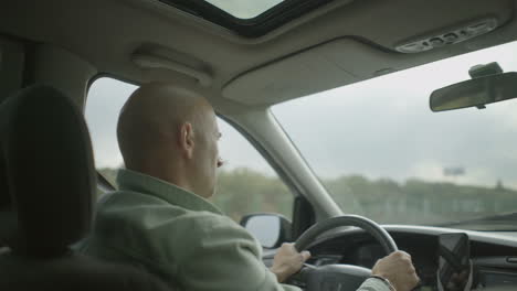 hombre serio de mediana edad conduciendo un coche