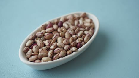 close up of dried borlotti beans in a white bowl