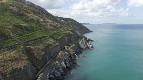 Zug,-Der-An-Einem-Tunnel-Vorbeifährt-Und-Ihn-Verlässt,-Mit-Klippenwanderung-Von-Bray-Zu-Greystones-In-Der-Nähe-Von-Dublin-Und-Bray-Town-In-Irland