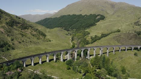 wide aerial view of the glenfinnan viaduct empty on a bright sunny day