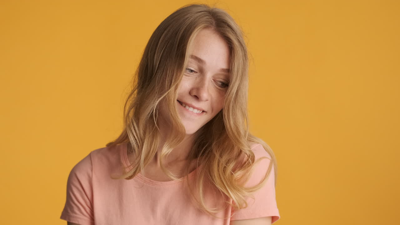 una mujer caucásica que se ve tímida ante la cámara.