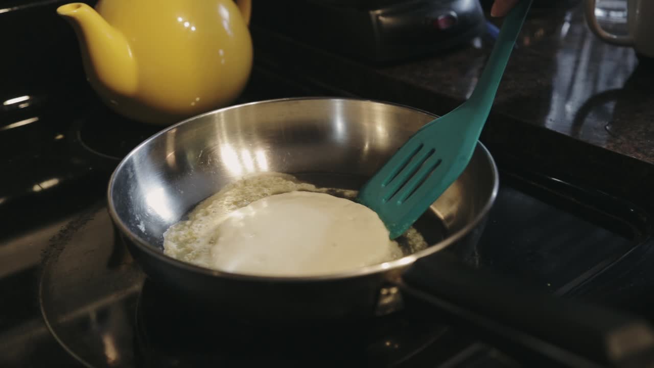 Närbild: Försiktigt för man in spateln under pannkakans kanter för att undvika att den går sönder.