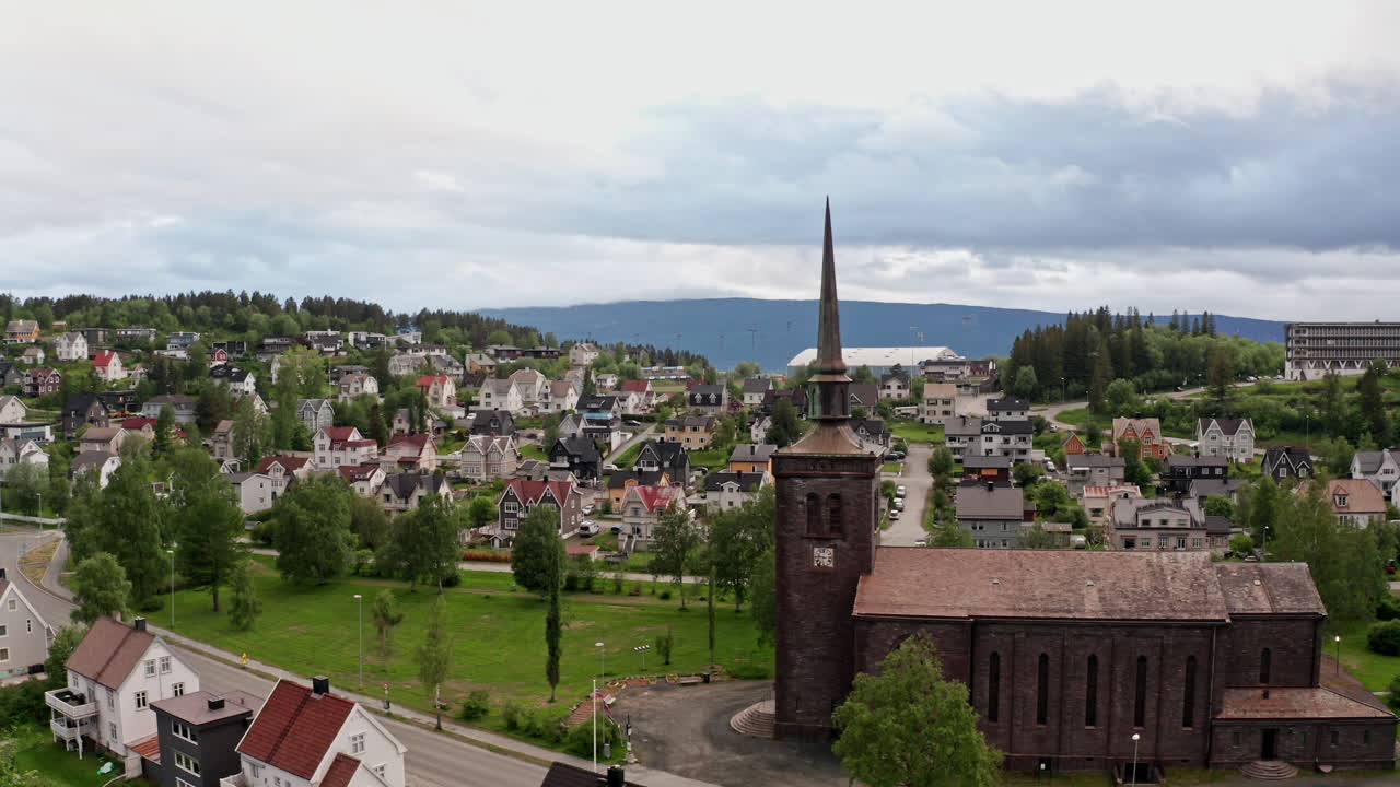 Aerial drone shot over the city of Narvik in Norway. High view of the local church, houses and buildings of the nordic town.