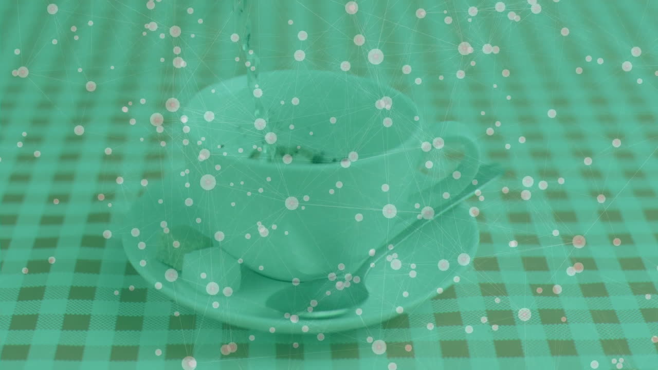 White teacup resting on saucer with teaspoon beside sugar cube, featuring network overlay