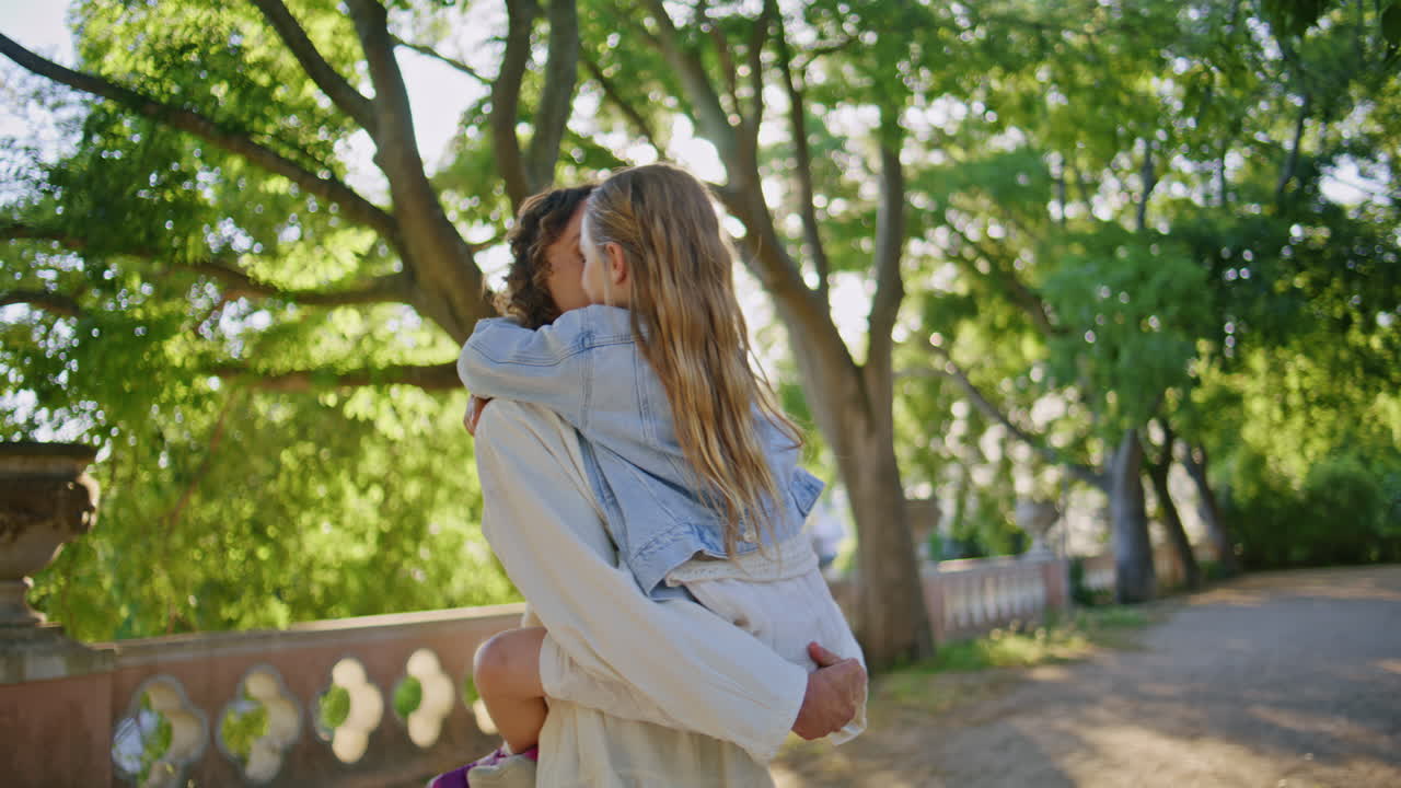 Happy mother raising daughter expressing love having fun on sunny nature closeup