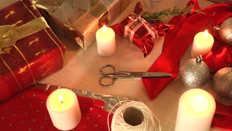 Cozy-christmas-background-with-candles,-gifts-and-other-wrapping-equipment