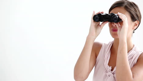 mujer bien vestida mirando a través de binoculares