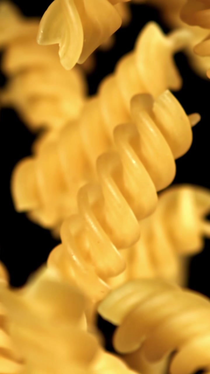 Fusilli Pasta Falling in Slow Motion on Black Background