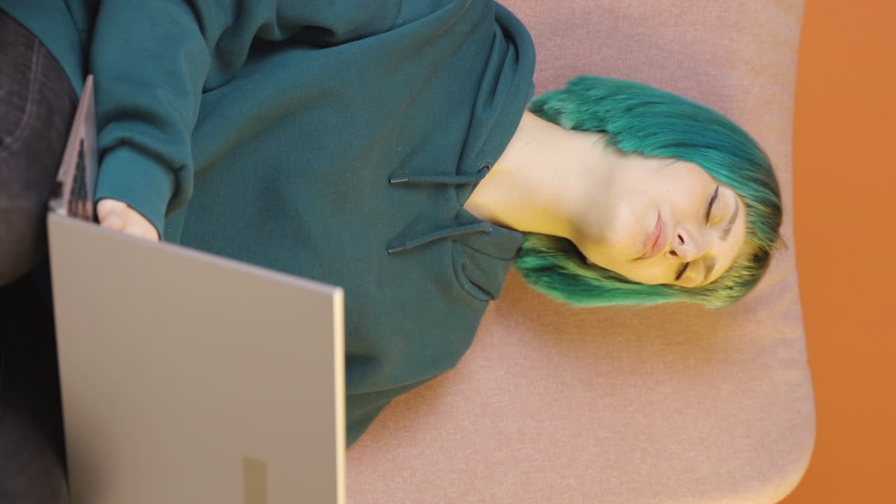 video vertical de la joven que se quedó dormida frente a una computadora portátil.