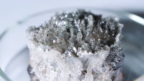 close-up of dark grey crystals in petri dish