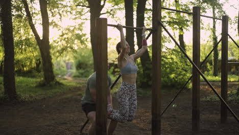woman doing pull-ups with assistance