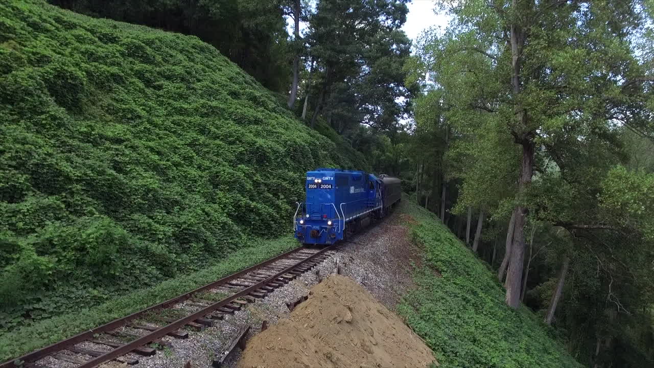 tren con motor diesel azul pasando por el borde de una montaña en tennessee