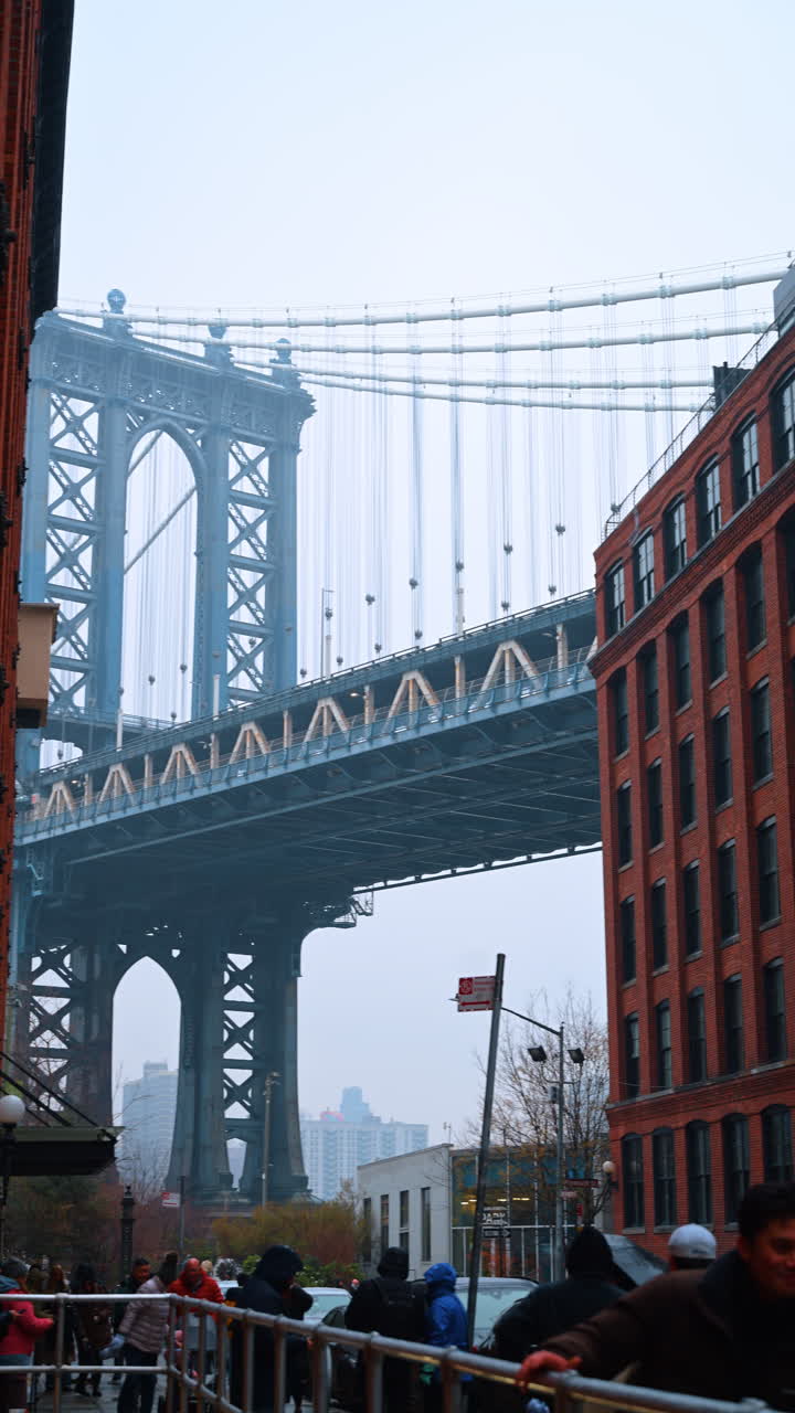New York, USA, 28 dicembre 2025: vista del Manhattan Bridge che collega Brooklyn e Manhattan a New York. Un alto ponte in acciaio si erge su una strada di Brooklyn. Edifici incorniciano la vista sotto il ponte
