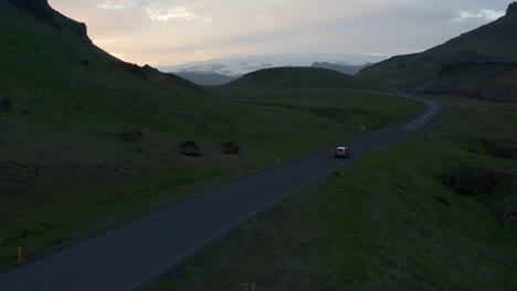 Drone-view-car-driving-the-ring-road-in-Iceland.-Aerial-view-car-driving-on-beautiful-road-with-amazing-panorama-landscape-of-grassy-icelandic-highland