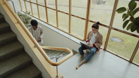 woman sitting on stairs and using laptop