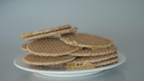 Mit-Der-Hand-Einen-Einzelnen-Keks-Aus-Einem-Haufen-Stroopwafels-Schnappen,-Eine-Typisch-Holländische-Leckerei