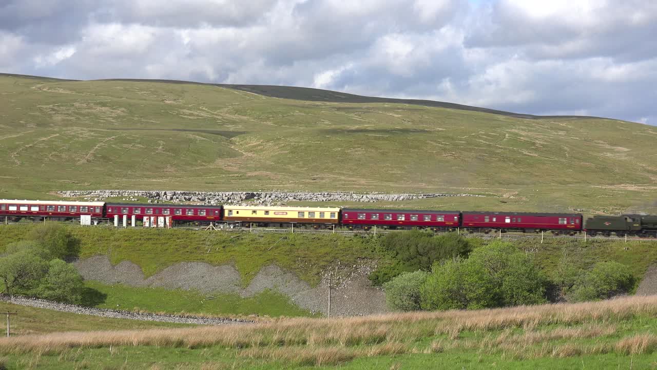 영국 시골의 언덕을 따라 증기 기관차가 지나간다