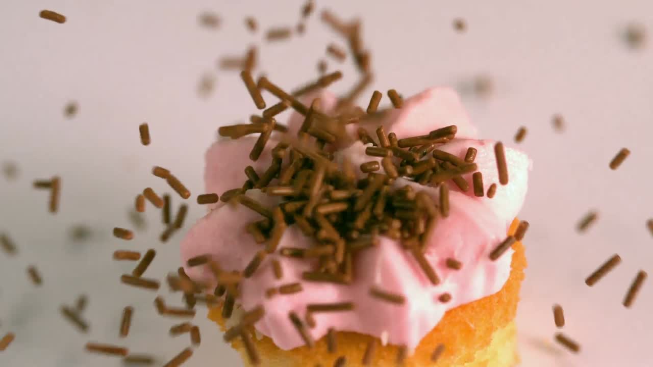 las salpicaduras de chocolate que caen sobre el pastel rosado rosado